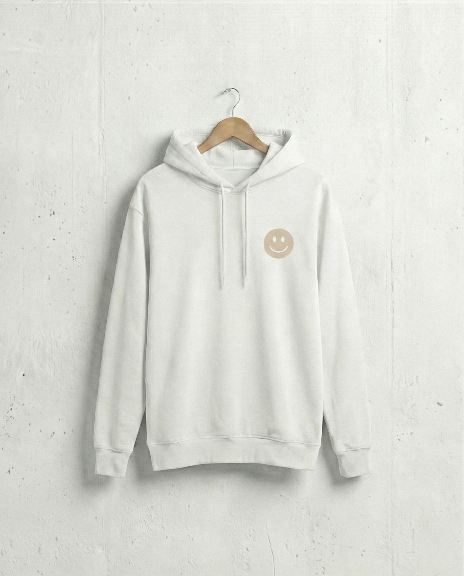 White hoodie with a smiley face logo on a hanger against a light gray background